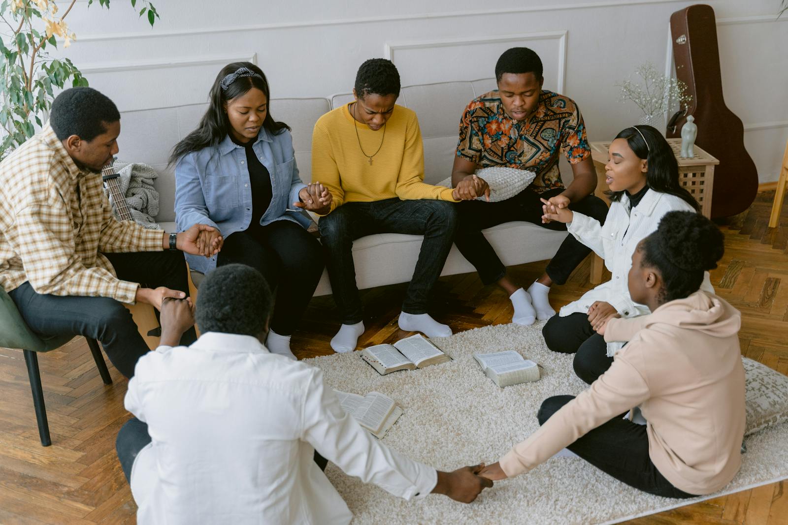 A group of people holding hands in prayer
